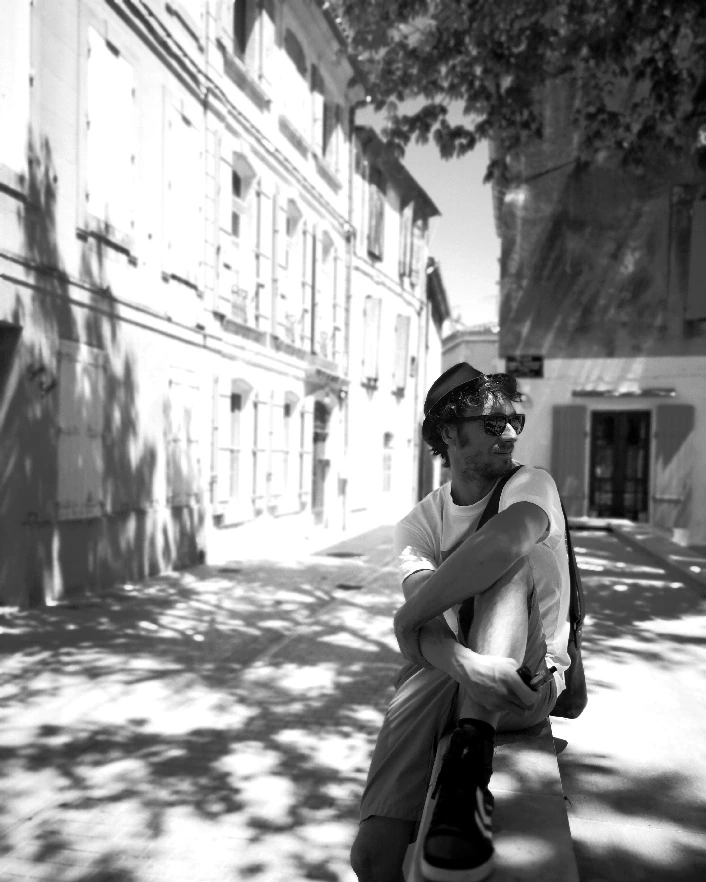 Aurélien Lafargue assis dans une rue, en contre-jour